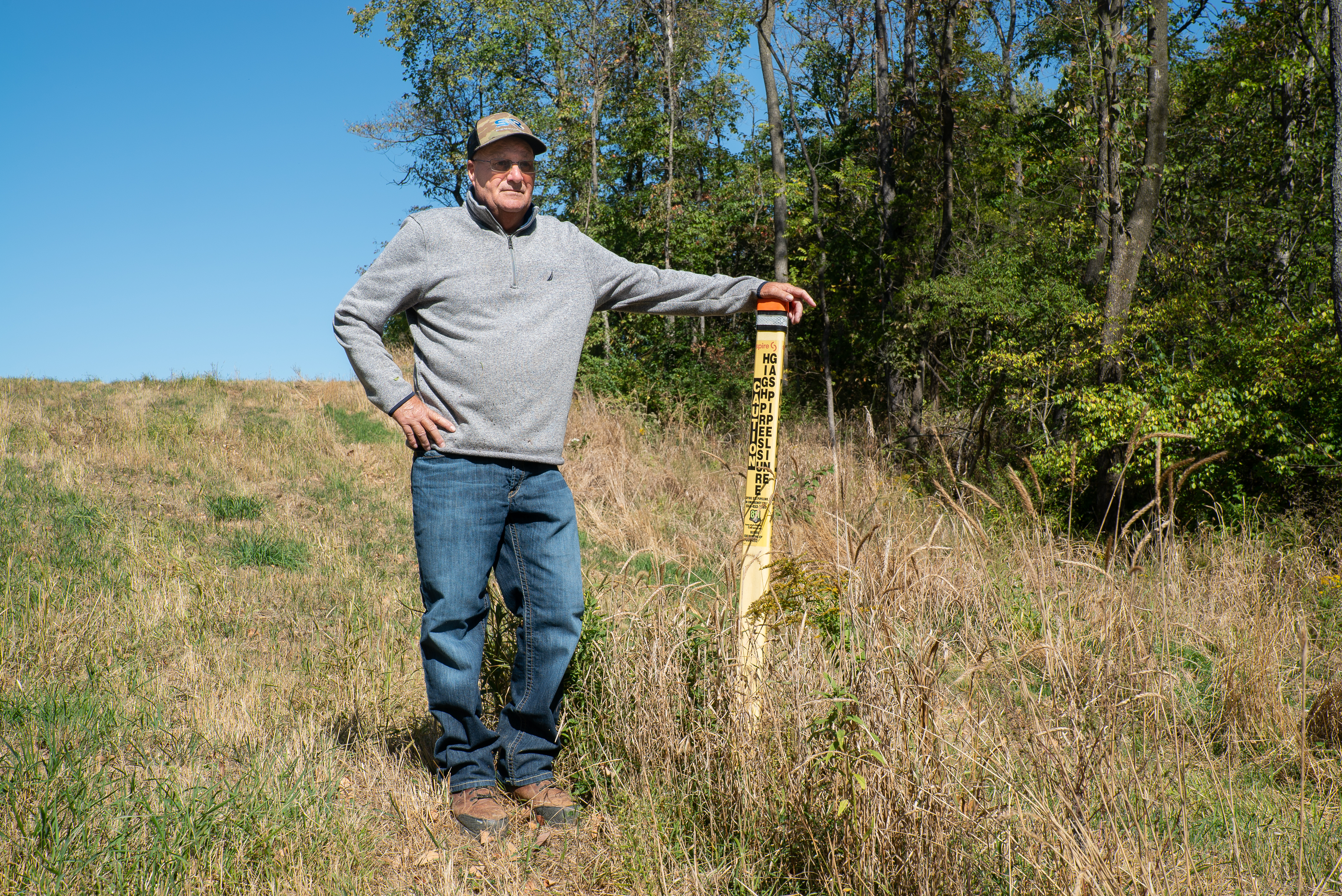 A man stands next to a gas pipeline flag