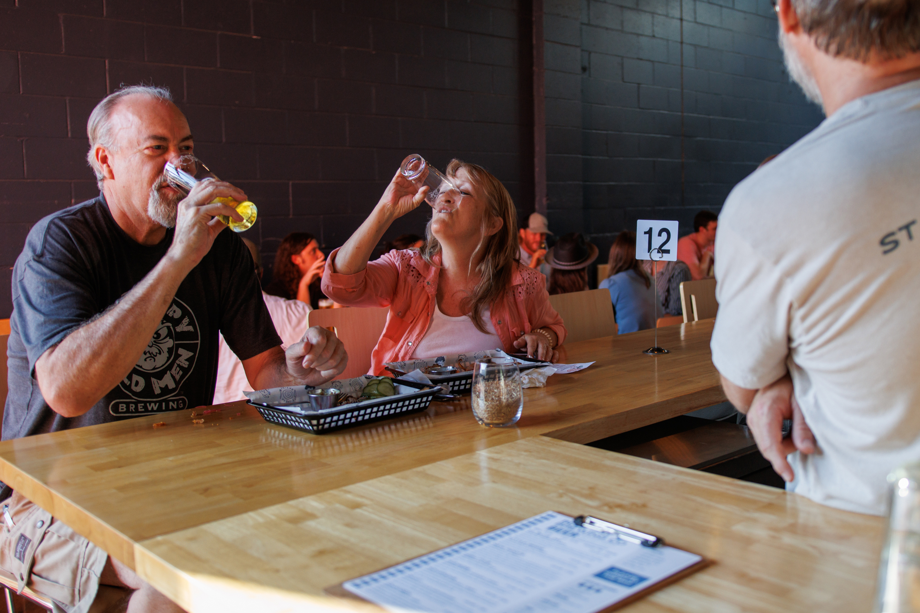 Two people drinking glasses of beer.